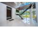 Bright, open foyer with a floating staircase, marble floors, and large windows offering beautiful views at 18725 Jiretz Rd, Odessa, FL 33556