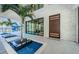 Impressive modern home entrance with a small water feature and a glimpse of a water slide at 18725 Jiretz Rd, Odessa, FL 33556