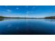 Beautiful lake view showcasing tranquil waters and the natural shoreline of mature trees and blue skies at 18725 Jiretz Rd, Odessa, FL 33556