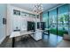 Modern office space featuring a large desk, built-in shelving, and windows with a view at 18725 Jiretz Rd, Odessa, FL 33556