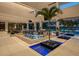 Expansive outdoor entertaining area with a built-in kitchen, palm trees, and inviting pool overlooking the lake at 18725 Jiretz Rd, Odessa, FL 33556