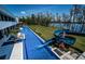 Luxury home exterior showcasing a long swimming pool with a slide, adjacent to a beautiful lake at 18725 Jiretz Rd, Odessa, FL 33556