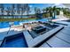 Resort-style pool area with a fire pit, lush landscaping, and a lake view, perfect for leisure at 18725 Jiretz Rd, Odessa, FL 33556