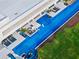 Aerial view of an enormous modern home showcasing an expansive pool with a slide, in-pool seating, and lush landscaping at 18725 Jiretz Rd, Odessa, FL 33556