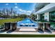 Stunning in-ground pool with lounge seating, paired with sleek black planters and lush greenery at 18725 Jiretz Rd, Odessa, FL 33556