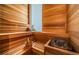 Wooden sauna with multiple levels of seating and a bucket of water next to hot stones at 18725 Jiretz Rd, Odessa, FL 33556