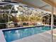 Relaxing enclosed outdoor pool area with clear water and surrounding trees at 2349 Holston Ave, Spring Hill, FL 34608