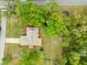 An aerial shot shows a well-kept lawn, mature trees, and a traditional-style home with ample yard space at 24104 Peppermill Dr, Brooksville, FL 34601