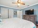 Relaxing bedroom featuring light blue walls, white trim, a ceiling fan and a dresser with a TV at 24104 Peppermill Dr, Brooksville, FL 34601