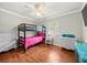 Cozy bedroom with bunk beds, hardwood floors, and a bright window at 24104 Peppermill Dr, Brooksville, FL 34601