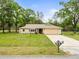Charming single-story home with a manicured lawn, paved driveway, and attached two-car garage at 24104 Peppermill Dr, Brooksville, FL 34601