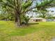 Charming home with a sprawling front yard, a mature tree, and lush landscaping for ultimate curb appeal at 24104 Peppermill Dr, Brooksville, FL 34601