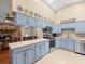 Spacious kitchen boasts blue cabinets, tile floors, and stainless-steel appliances at 24104 Peppermill Dr, Brooksville, FL 34601
