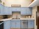 Bright kitchen with blue cabinets, stainless appliances, and plenty of counter space at 24104 Peppermill Dr, Brooksville, FL 34601