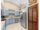 Well-lit kitchen offers blue cabinetry, tile floor, stainless steel appliances, and ample storage at 24104 Peppermill Dr, Brooksville, FL 34601