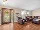Comfortable living room featuring wood floors, ample seating, and a decorative front door at 24104 Peppermill Dr, Brooksville, FL 34601