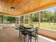 Inviting screened porch with brick floors, wood ceiling, and a backyard view and furniture at 24104 Peppermill Dr, Brooksville, FL 34601