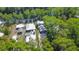 Close aerial shot of the residence surrounded by trees, parking for two vehicles, and a lush wooded area at 28330 Peterson Camp Rd, Brooksville, FL 34601