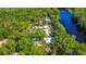 Expansive aerial perspective revealing multiple residences nestled amidst a verdant canopy along the waterfront at 28330 Peterson Camp Rd, Brooksville, FL 34601