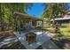 Spacious backyard with covered grilling area, outdoor seating, fire pit, and access to waterfront at 28330 Peterson Camp Rd, Brooksville, FL 34601