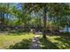 Lush backyard leading to water with dock, covered seating area, mature trees, and manicured lawn at 28330 Peterson Camp Rd, Brooksville, FL 34601