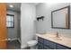 Cozy bathroom featuring blue vanity, white toilet, and a glass-door shower, offering a fresh, stylish look at 28330 Peterson Camp Rd, Brooksville, FL 34601