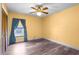 Bedroom featuring warm yellow walls, wood-look floors, and a ceiling fan at 28330 Peterson Camp Rd, Brooksville, FL 34601