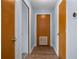 Hallway with wood-look floors, fresh paint, and multiple wood paneled doors at 28330 Peterson Camp Rd, Brooksville, FL 34601