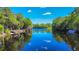 A scenic river view showcasing calm waters, a covered dock, and a bright blue sky with a few puffy clouds at 28330 Peterson Camp Rd, Brooksville, FL 34601