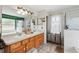 Bathroom vanity with double sinks, cabinets, framed mirror, and walk-in shower at 3017 Aldoro Ave, Spring Hill, FL 34609