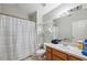 Bathroom with single sink vanity, mirror, toilet, and shower with curtain at 3017 Aldoro Ave, Spring Hill, FL 34609
