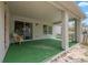 View of a covered patio with astroturf flooring and a wicker chair, with a sliding glass door at 3017 Aldoro Ave, Spring Hill, FL 34609