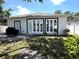 A spacious backyard featuring large glass doors, a grill, and lush greenery at 3037 Leroy W St, Tampa, FL 33607