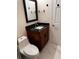 Bathroom with a dark wood vanity, black marble top, and a modern mirror at 3037 Leroy W St, Tampa, FL 33607
