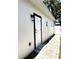 Side exterior view of home with a white door and black trim, plus a paver walkway at 3037 Leroy W St, Tampa, FL 33607