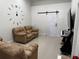 Comfortable living room with reclining sofa seating, a large wall clock, and a sliding barn door at 3037 Leroy W St, Tampa, FL 33607