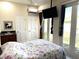 Bright main bedroom with a floral patterned bedspread, ensuite, and French doors to the outside at 3037 Leroy W St, Tampa, FL 33607