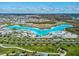 Aerial view of community resort-style lagoon with clubhouse, slides, white sand beaches, and palm trees perfect for vacation vibes at 30839 Penny Surf Loop, Wesley Chapel, FL 33545