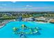 Aerial view of community resort-style lagoon with large inflatable obstacle course and clubhouse perfect for the active Gathering at 30839 Penny Surf Loop, Wesley Chapel, FL 33545
