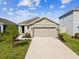 Charming single-story home featuring a well-manicured lawn and an attached two-car garage at 30839 Penny Surf Loop, Wesley Chapel, FL 33545