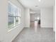 Bright hallway showcasing neutral tile flooring, access to different rooms, and a view to the backyard at 30839 Penny Surf Loop, Wesley Chapel, FL 33545