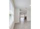 Bright hallway featuring neutral tile flooring, backyard view, and access to an open floorplan at 30839 Penny Surf Loop, Wesley Chapel, FL 33545