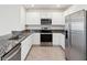 A well-lit kitchen featuring stainless steel appliances and granite countertops with ample cabinet space at 30839 Penny Surf Loop, Wesley Chapel, FL 33545