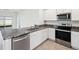 A bright kitchen with modern stainless steel appliances, granite countertops, and white cabinets at 30839 Penny Surf Loop, Wesley Chapel, FL 33545