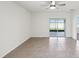 Open living room featuring tile floors and a glass sliding door leading to a screened-in patio at 30839 Penny Surf Loop, Wesley Chapel, FL 33545