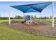 Community playground featuring a covered play structure, swings, and slides in a Gathering-friendly environment at 30839 Penny Surf Loop, Wesley Chapel, FL 33545