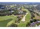 Breathtaking aerial view of property overlooking a lush golf course, lake, and landscaped community at 3160 Whispering Pines Ct, Spring Hill, FL 34606