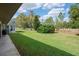 Large, well-maintained backyard with mature trees and a patio area perfect for outdoor entertaining at 3160 Whispering Pines Ct, Spring Hill, FL 34606