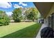 Lush green backyard featuring mature trees, a patio, and a well-maintained lawn at 3160 Whispering Pines Ct, Spring Hill, FL 34606