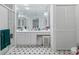 Bright bathroom with white cabinets, full mirror, and classic black and white checkered tile at 3160 Whispering Pines Ct, Spring Hill, FL 34606